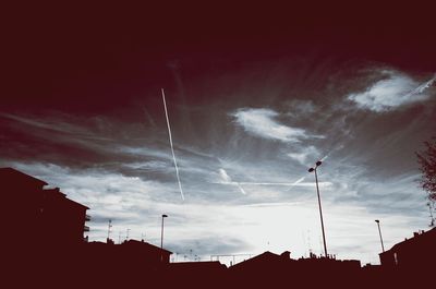 Low angle view of silhouette buildings against sky