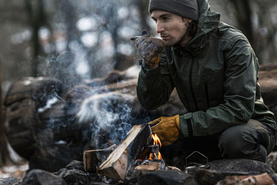 Man sitting at log fire