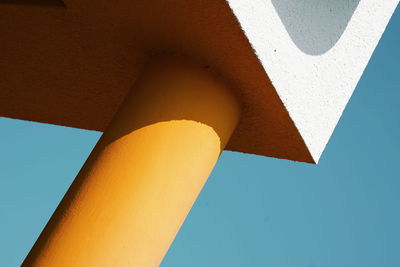Low angle view of yellow wall against blue sky