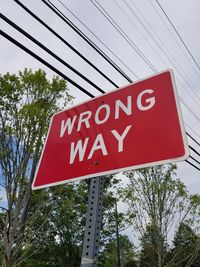 Low angle view of road sign against sky