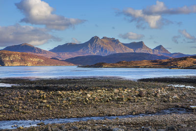 Scenic view of sea and mountains against sky