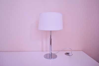 Lamp on table by wall