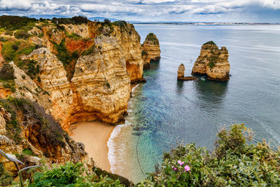 Scenic view of rocks on sea against sky