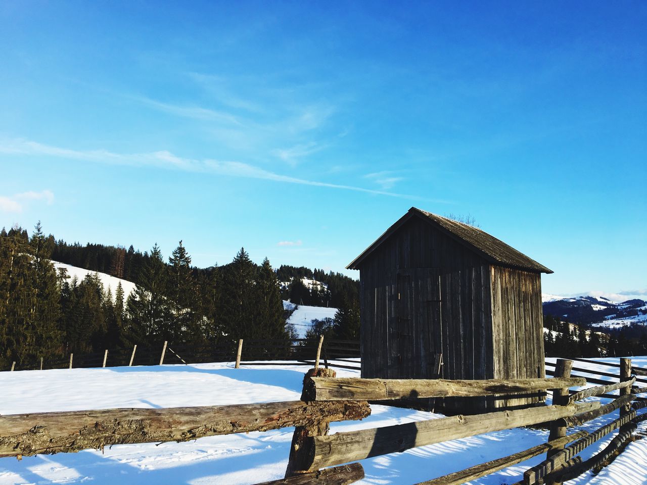 sky, snow, winter, cold temperature, built structure, architecture, blue, day, nature, wood - material, building exterior, sunlight, tranquility, no people, cloud - sky, beauty in nature, barrier, scenics - nature, fence, outdoors, snowcapped mountain