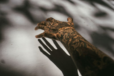 Tattooed hand of woman by wall
