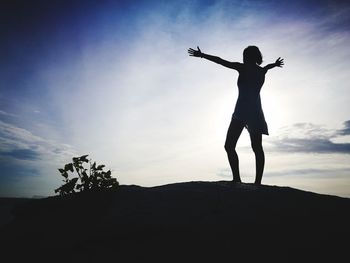 Low angle view of silhouette woman standing against sky