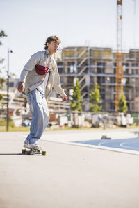 Young man skateboarding on footpath