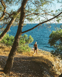 Woman walking at beach against sky