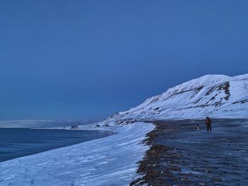 Scenic view of snowcapped mountains against clear blue sky