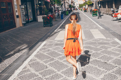 Rear view of woman walking on street in city