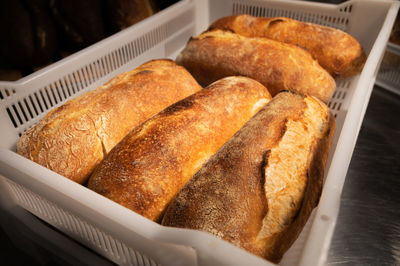 Fresh rolls of craft craft bread lies on the table in the bakery. loading hot bread 