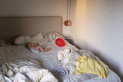 High angle view of baby girl sleeping on bed at home