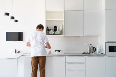 Rear view of man standing at home