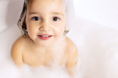 Portrait of cute baby girl in bathtub