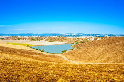 Scenic view of land against blue sky