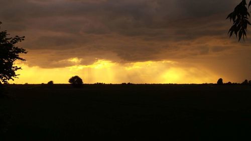 Silhouette of landscape against cloudy sky