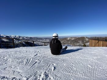 Man on snowcapped mountain against sky