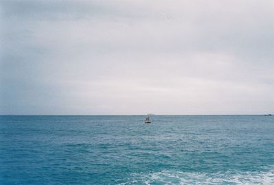 Scenic view of calm sea against cloudy sky