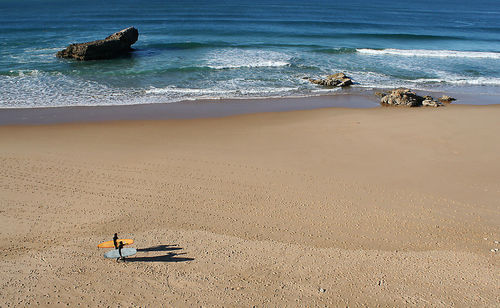 High angle view of people with surfboard walking on sand at beach