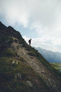 Man standing on cliff against sky