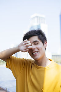 Portrait of smiling young man against sky