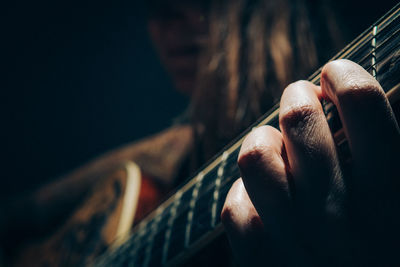 Close-up of man playing guitar