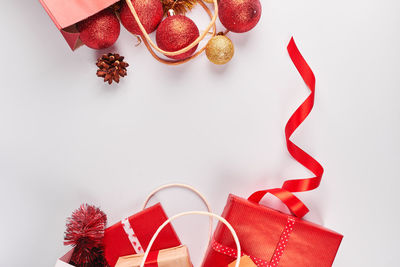 High angle view of shopping bags and christmas decorations against white background