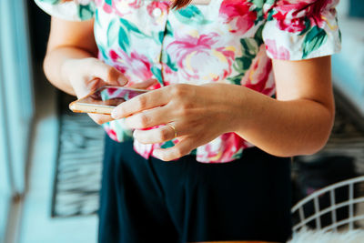 Midsection of woman holding mobile phone