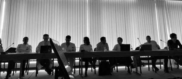 Rear view of people sitting on table