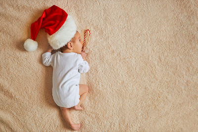 High angle view of baby boy sitting on bed at home