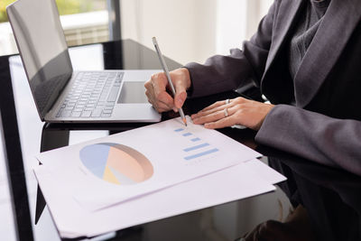 Close up desktop of young and smart business woman manager who is working on data analysis 