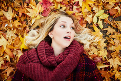 Young woman lying on autumn leaves