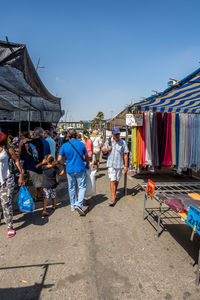 People at market stall against clear sky