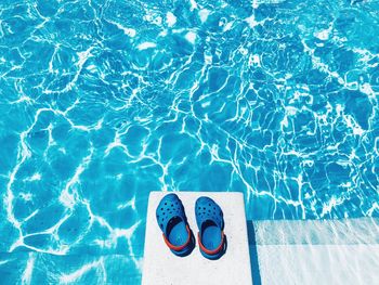 High angle view of shoes on diving board over swimming pool