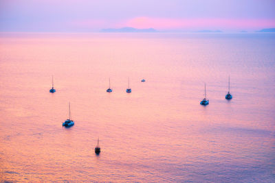 Tourist yachts boat in aegean sea near santorini island at sunset viewpoint. santorini, greece