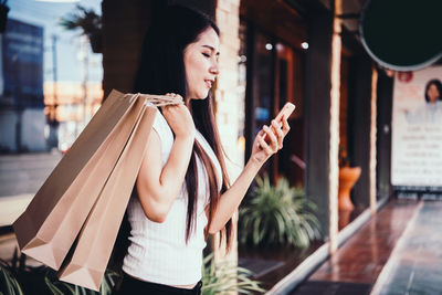 Midsection of woman standing by window at store