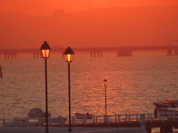 View of lights on beach during sunset