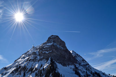 Low angle view of snow covered mountain against sky