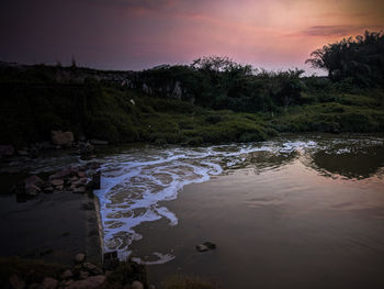 Scenic view of river against sky during sunset