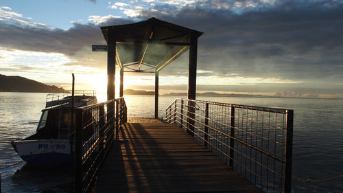 Pier over sea against sky during sunset