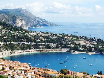 Aerial view of city by sea against sky