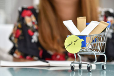 Midsection of woman holding coffee cup on table at store