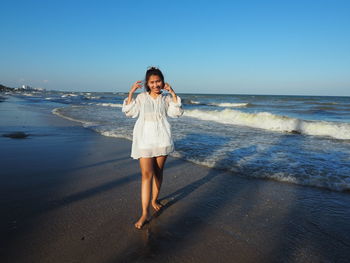 Full length of woman on beach against clear sky