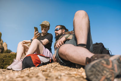 Smiling man sharing smart phone with friend