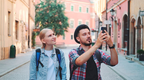 Portrait of smiling friends standing in city