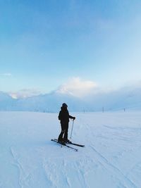 Rear view of man skiing on snow covered landscape