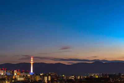 Illuminated buildings against sky at sunset