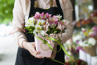 Midsection of woman holding flower bouquet