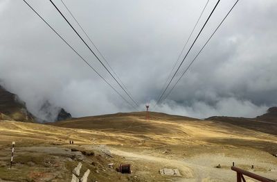 View of ski lift against cloudy sky