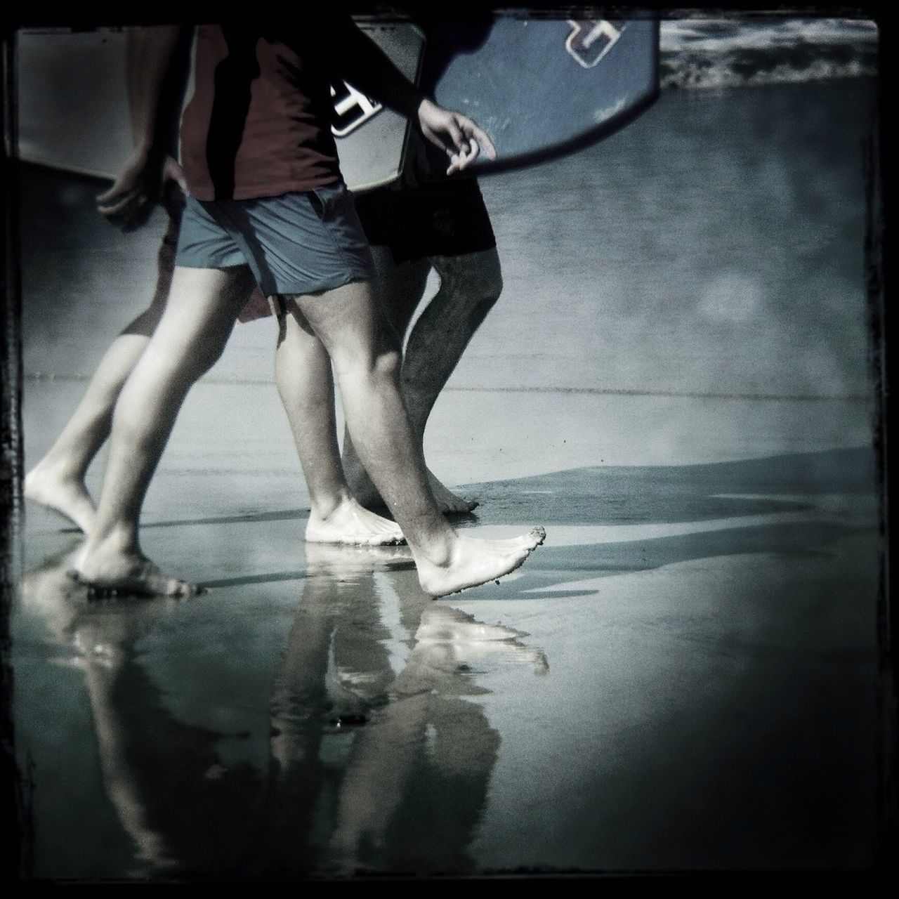lifestyles, low section, leisure activity, transfer print, water, person, auto post production filter, standing, sea, men, beach, reflection, walking, enjoyment, wet, togetherness